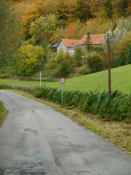 a road sign is pictured along a rural country road