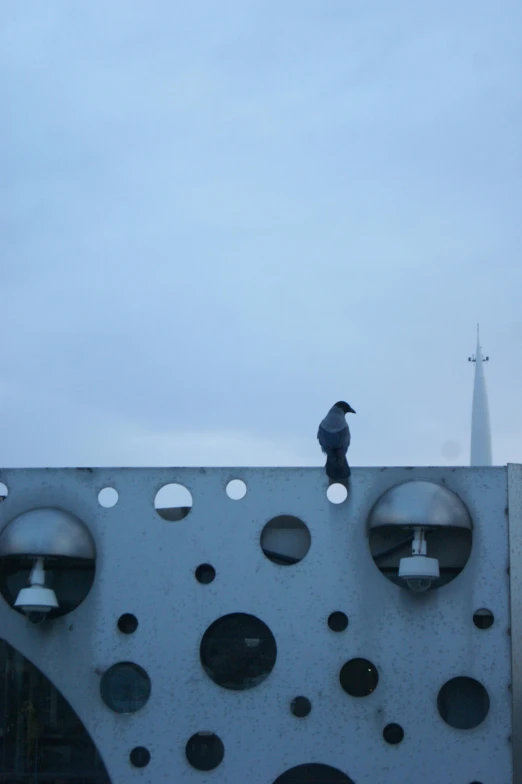 a bird on top of a wall with bells