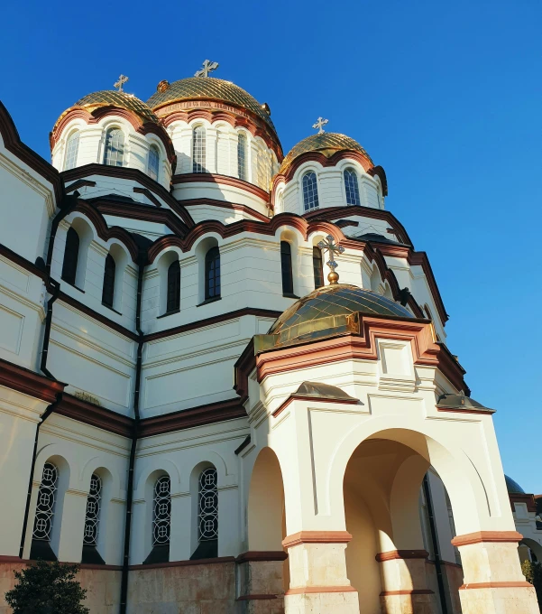 the beautiful architecture is painted white and has a gold and red roof