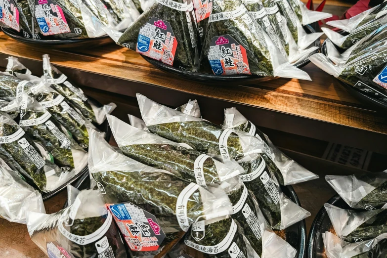 several packages of pickled green peppers in bags on display