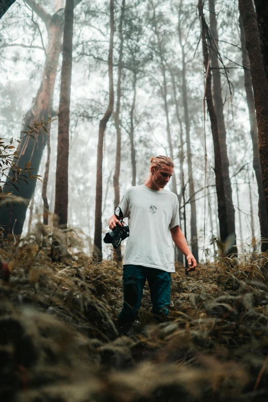 a man stands among the trees on a cloudy day