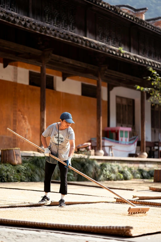 a man standing on a patch of concrete with a walking stick