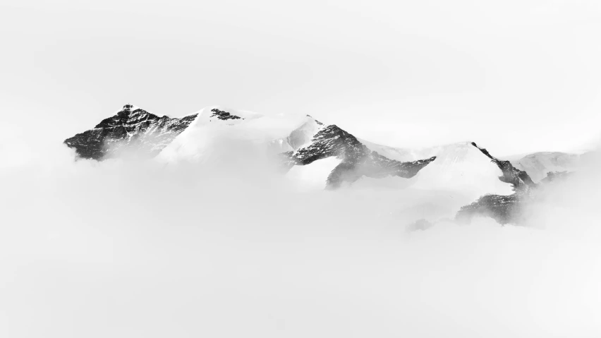 snow covered mountains with a skier skiing near by