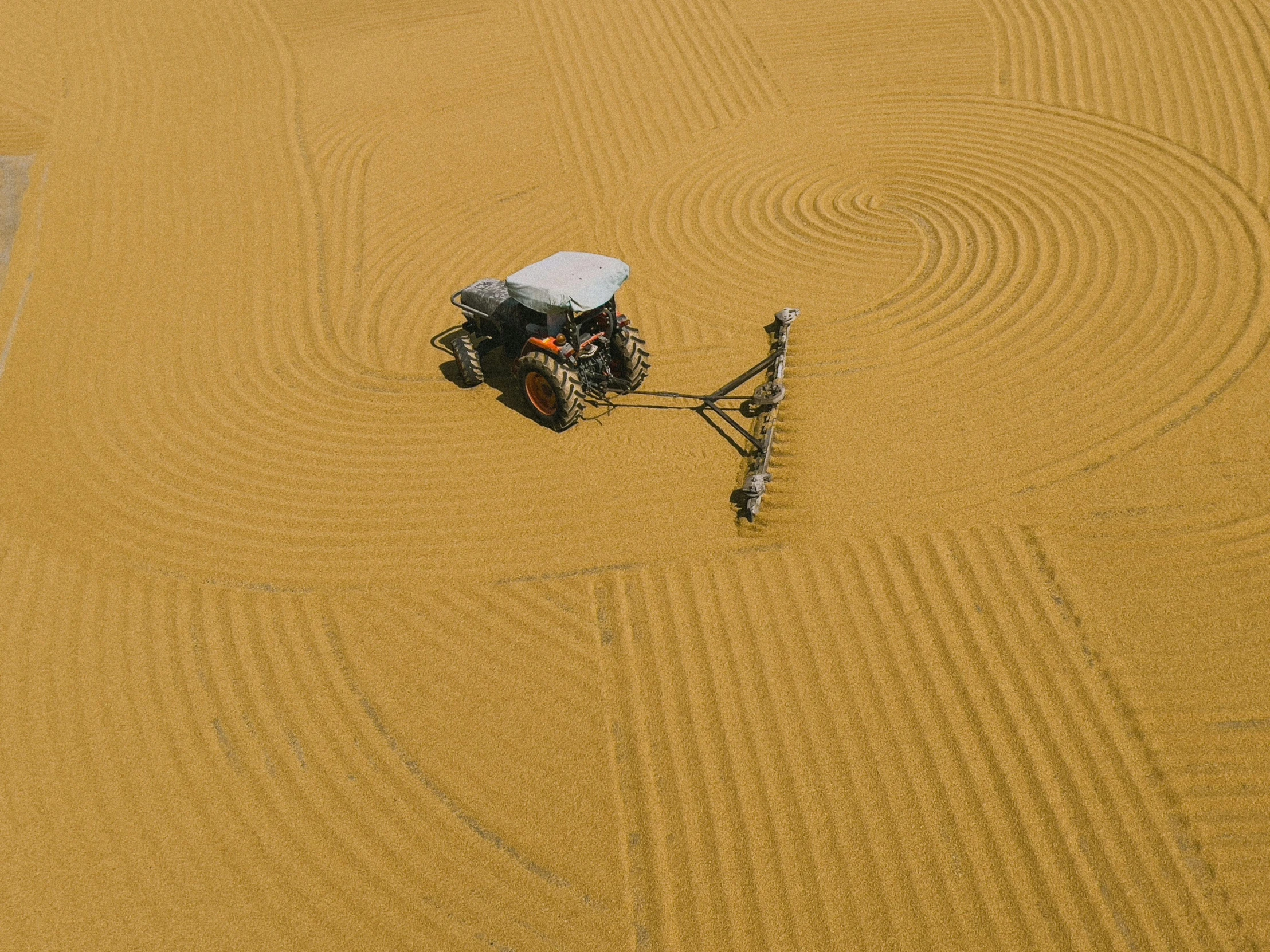 an aerial view of a yellow tractor on a desert