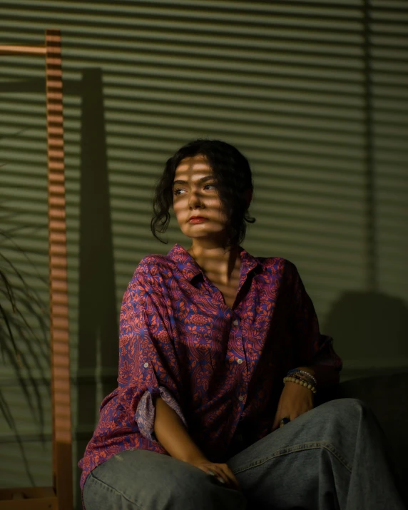 a woman with a purple shirt and green pants poses for a portrait