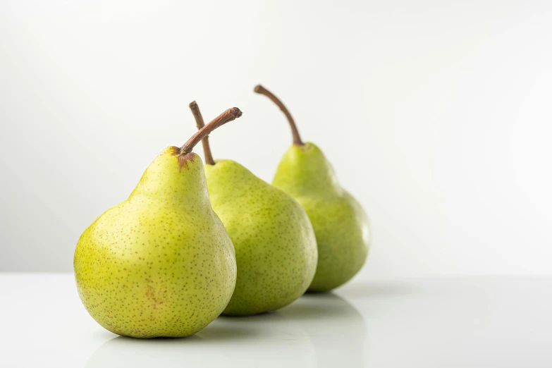 three pears with the one fruit still ripe