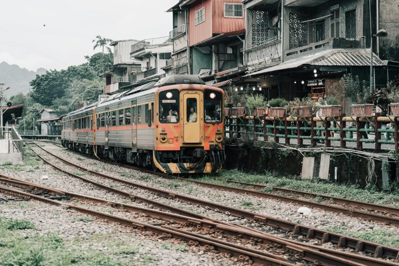 an orange train stopped at a train station