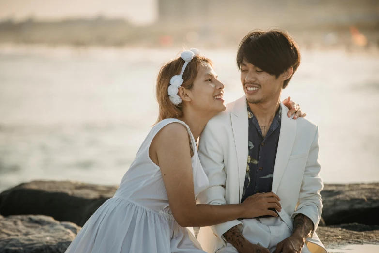 a man is sitting on a rock next to a woman