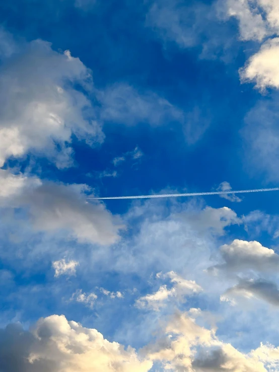 a plane flying in a cloudy blue sky