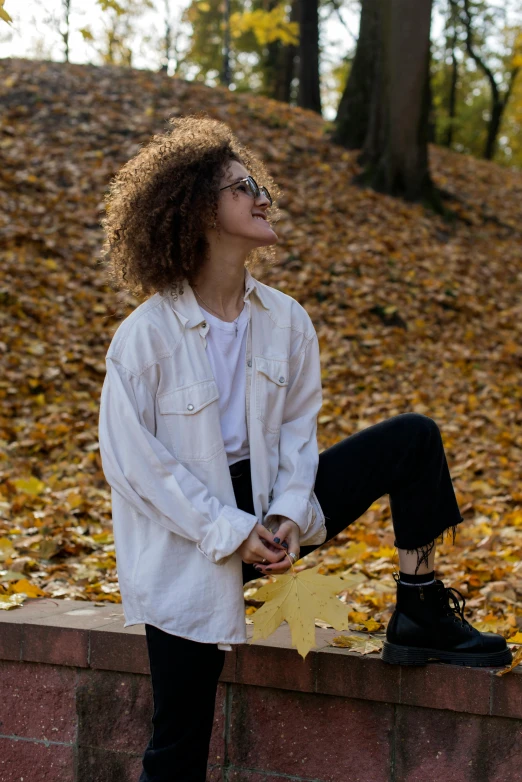 a woman is sitting on a stone wall and smiling