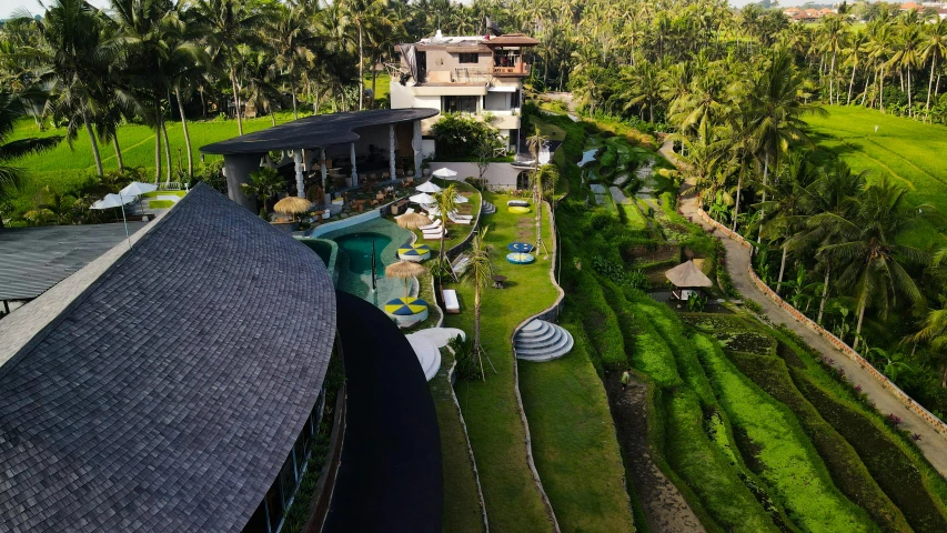 an aerial view of a large home surrounded by palm trees