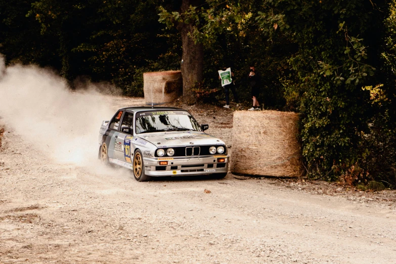 a man driving a car on top of a dirt road