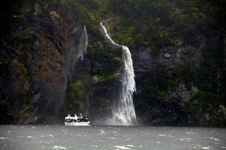 there is a small boat that is next to a waterfall