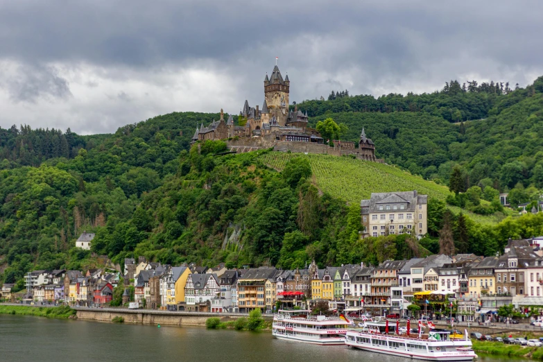 a large castle sitting on top of a hill next to water