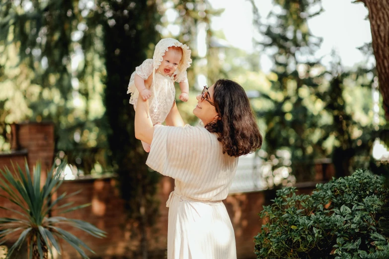 a woman holding up a baby in the air