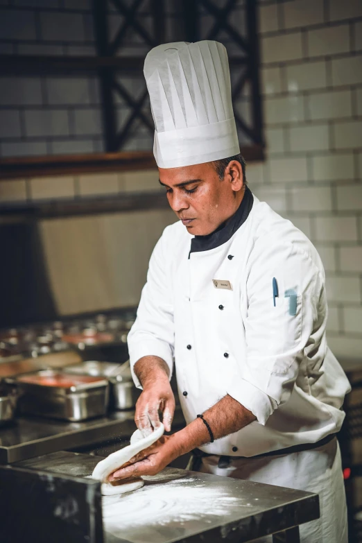 man in the kitchen making pizza crust