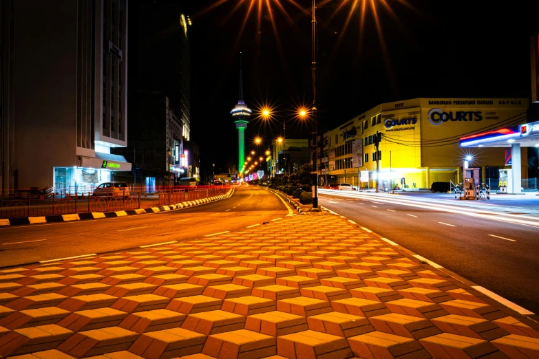 a street at night with a bright yellow and black checkerboard walk way