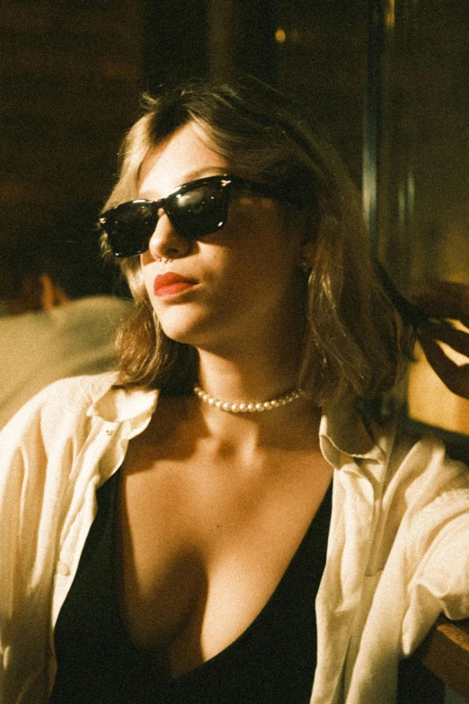 a young woman in sunglasses is sitting down