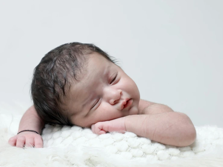 a baby is sleeping on a blanket with it's face close to the camera
