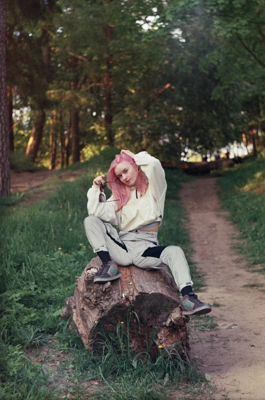 a person sitting on a tree stump in the forest