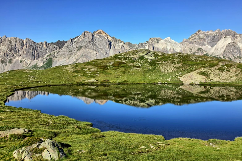 a beautiful landscape with many mountains, lakes and grassy area