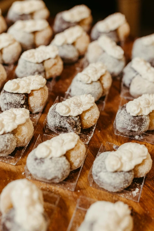 many mini cakes covered with icing sit in a grid