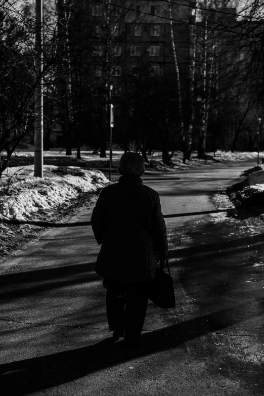 black and white image of a man walking in the snow