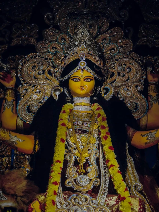 the idol is adorned with gold and flowers