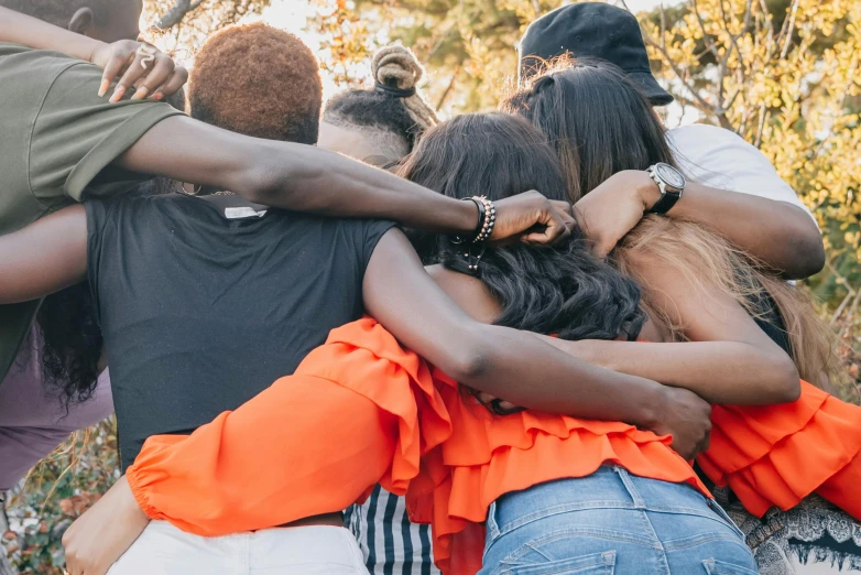 the group of people are huddled together in a circle