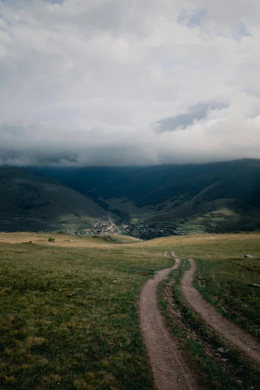 a dirt road is running through an open field