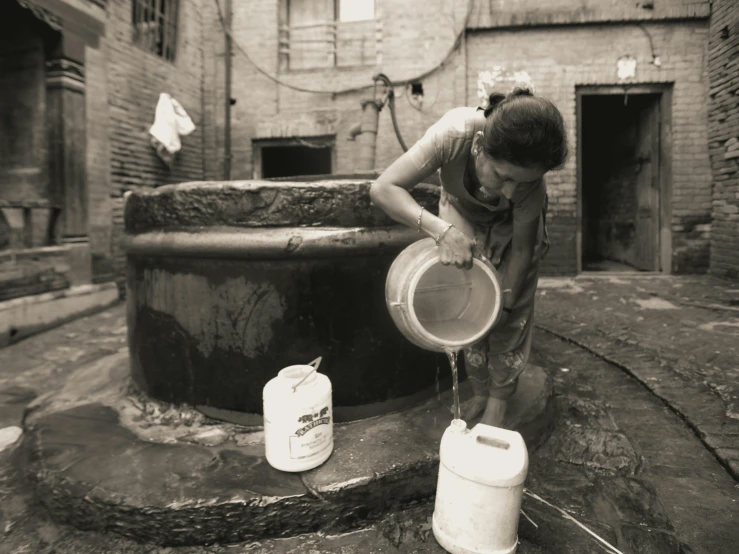 a man in old clothing doing maintenance on a water well