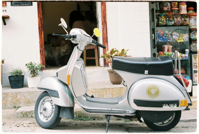 a scooter is parked in front of an open shop