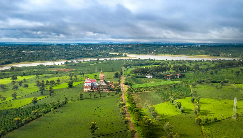 a large church sits on the edge of a big green field