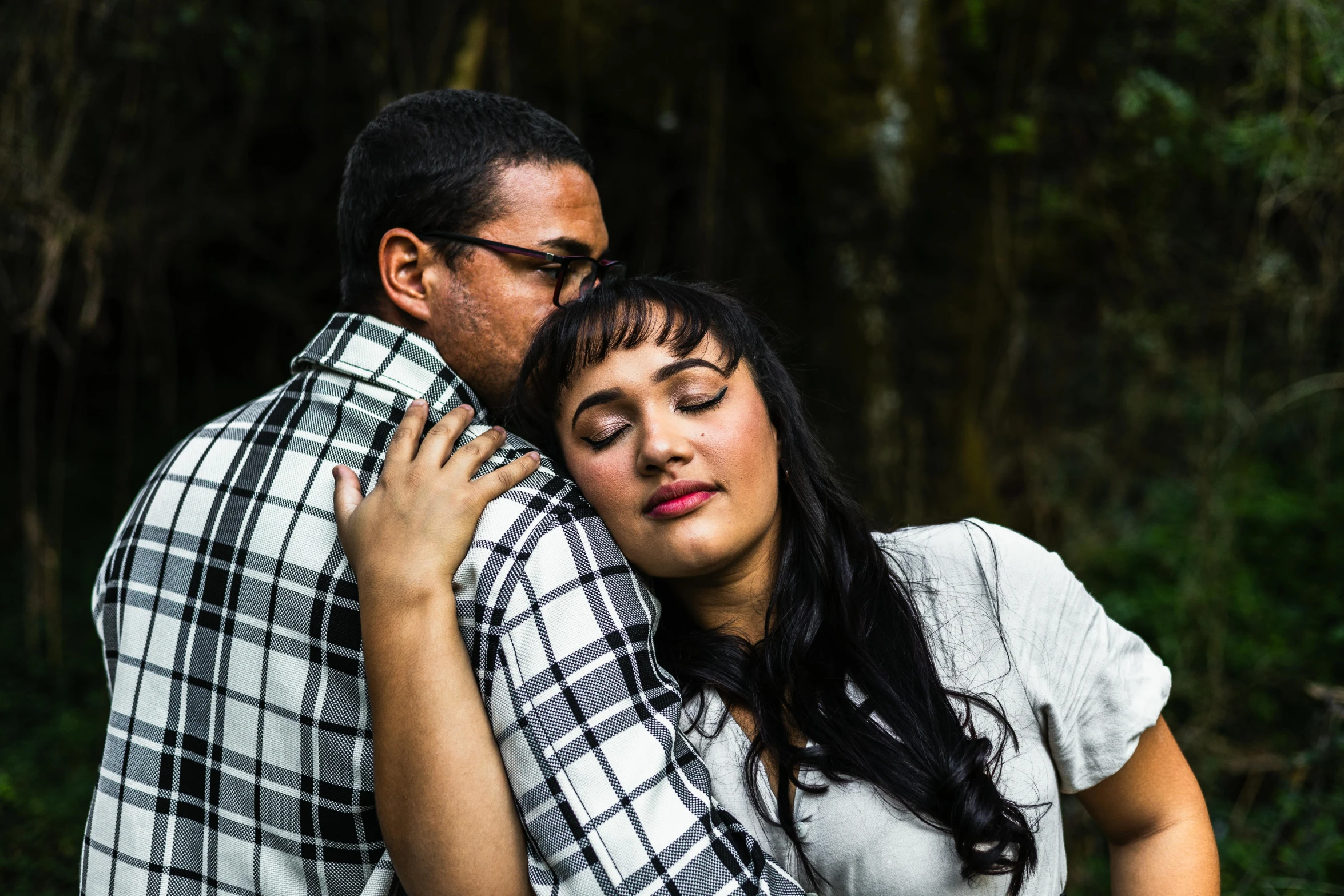 a woman and a man who are hugging with the woman emcing her