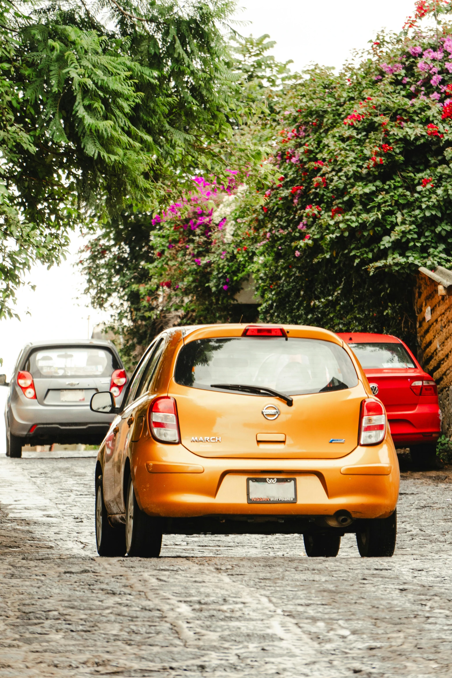 there is an orange car parked in the street