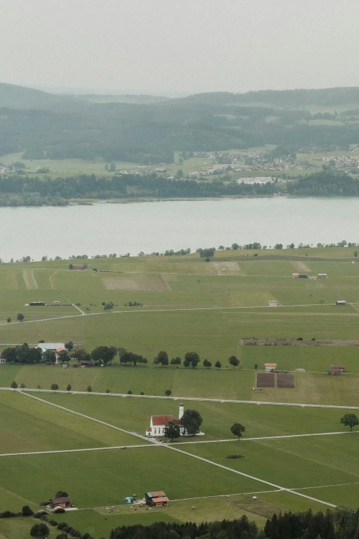 an empty field in the country with water and houses