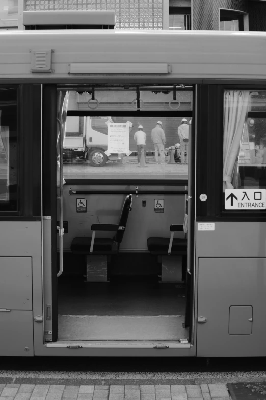 an open bus door with benches sitting outside