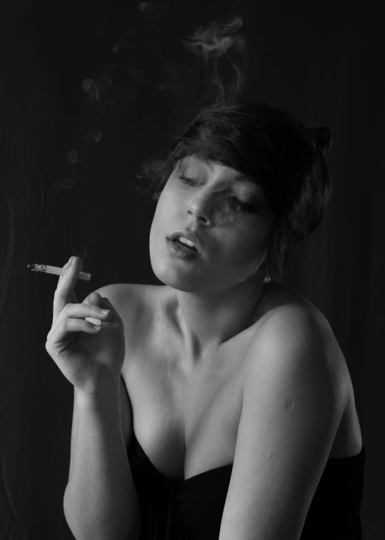 a woman in black top holding cigarette and smoking