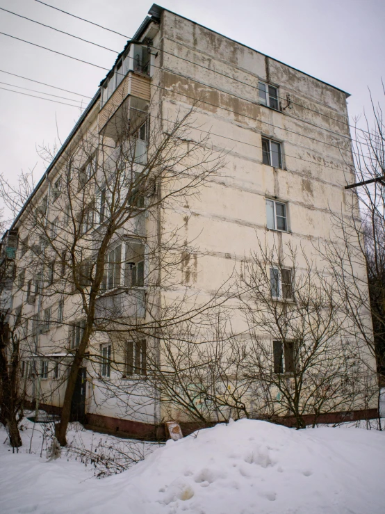 building in the middle of a snowy area, against grey sky