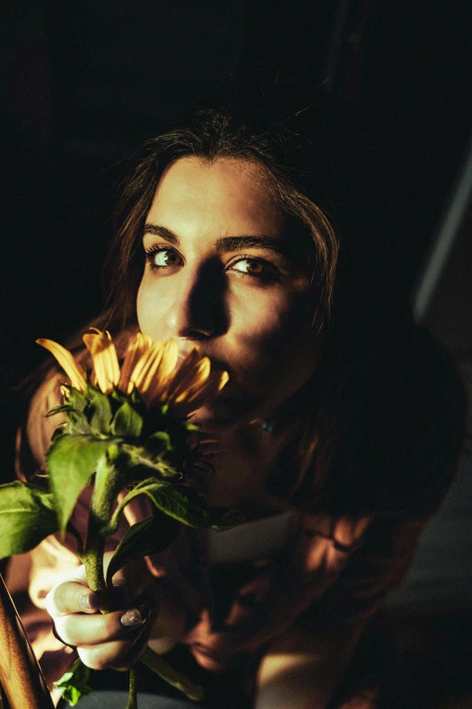 a woman that is holding a flower in her hand