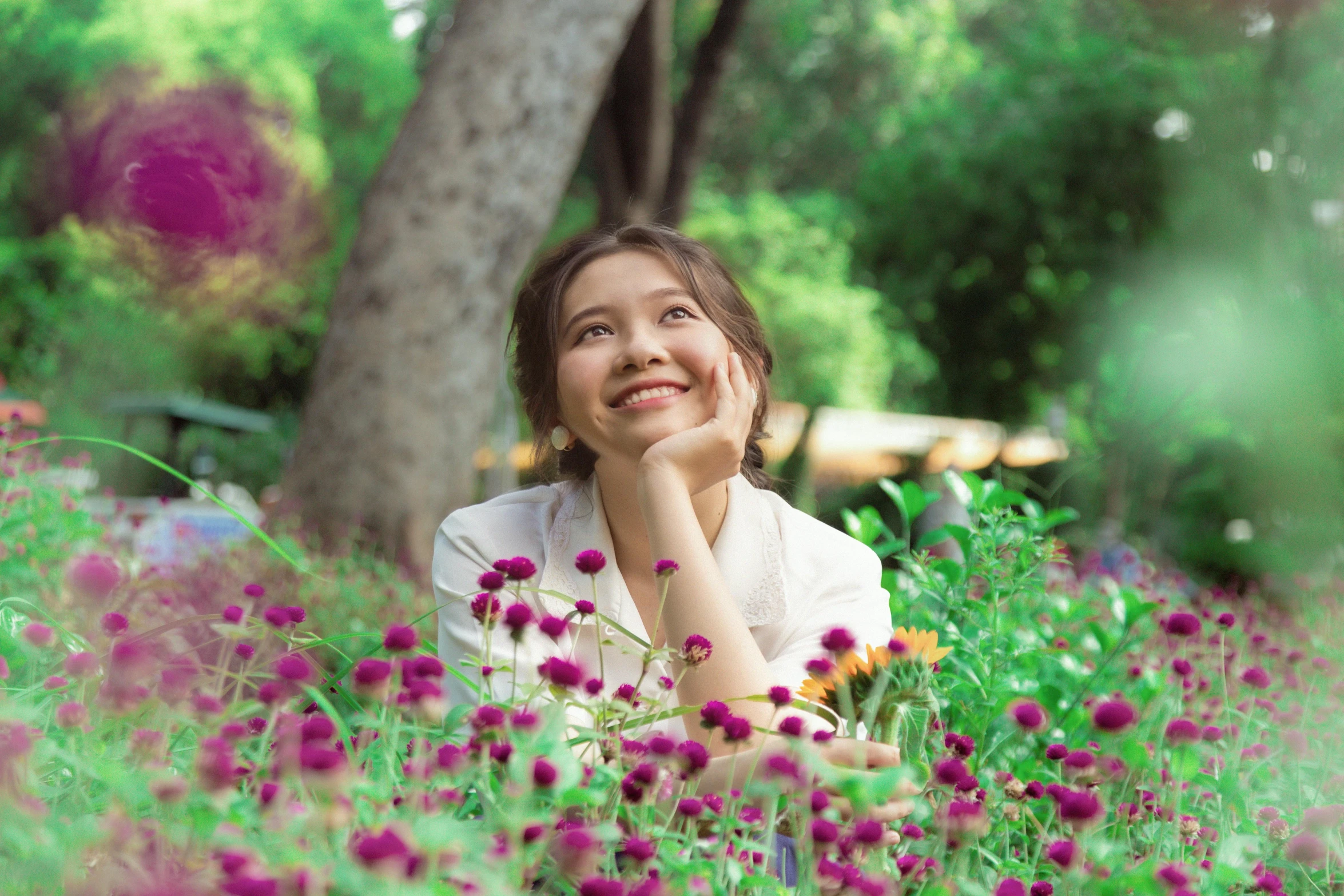 a woman is smiling and laying down in the grass