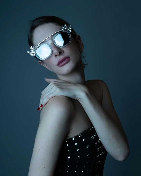 a woman wearing glasses with red nail polish on her hand