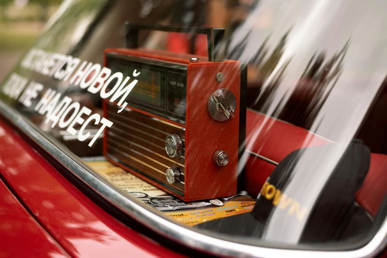 a red car with its roof removed and the reflection of it