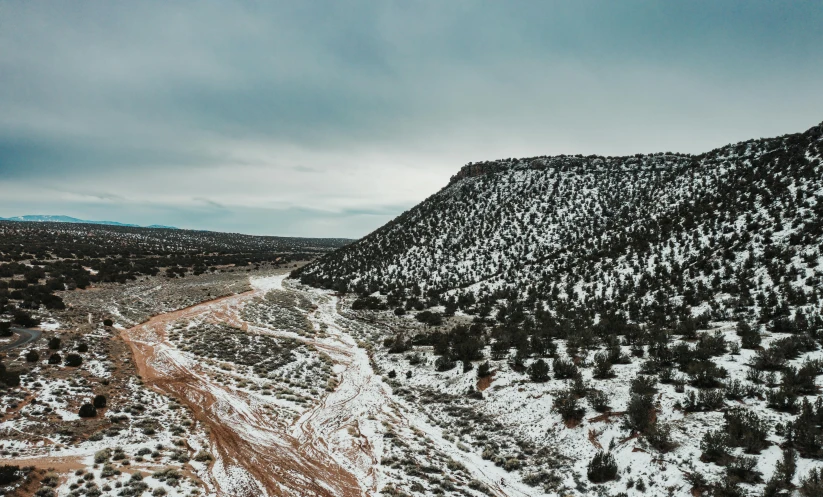 a snow covered mountain landscape with a stream