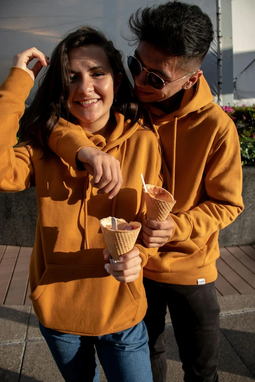 two people smiling with ice cream cones in each hand