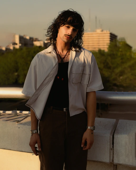 a man is posing for a picture near water