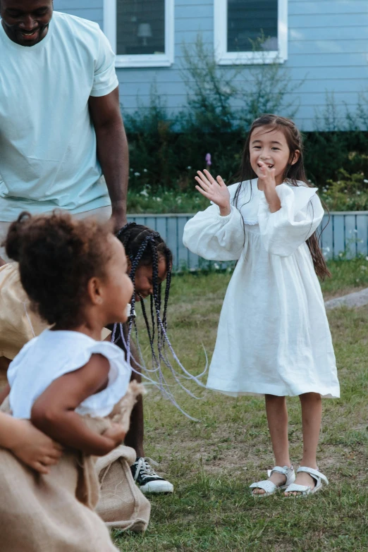 a little girl with hands out to greet a man