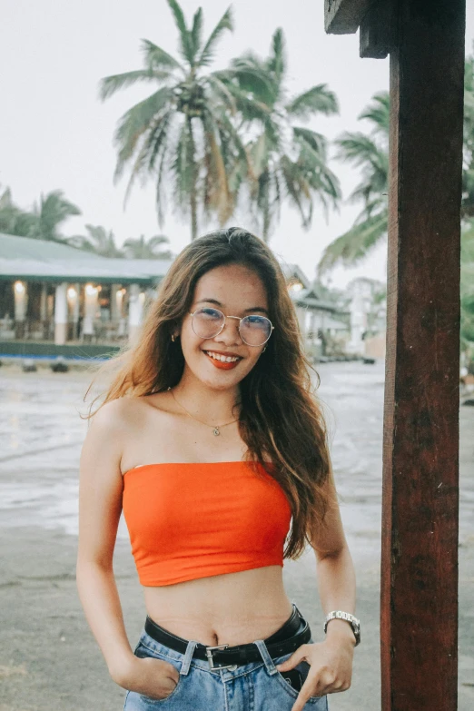 a woman in a cropped top standing on the beach