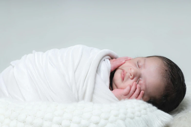 a small child that is laying down with a blanket on it