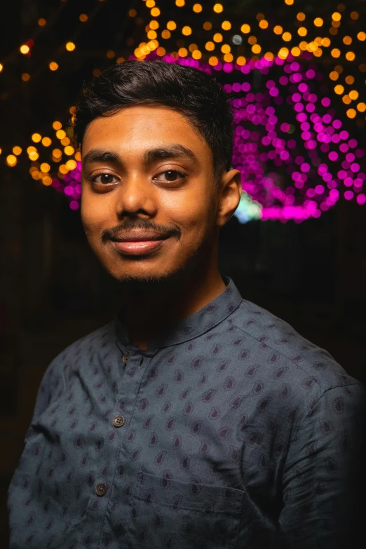 the man is posing for a po with the lights behind him